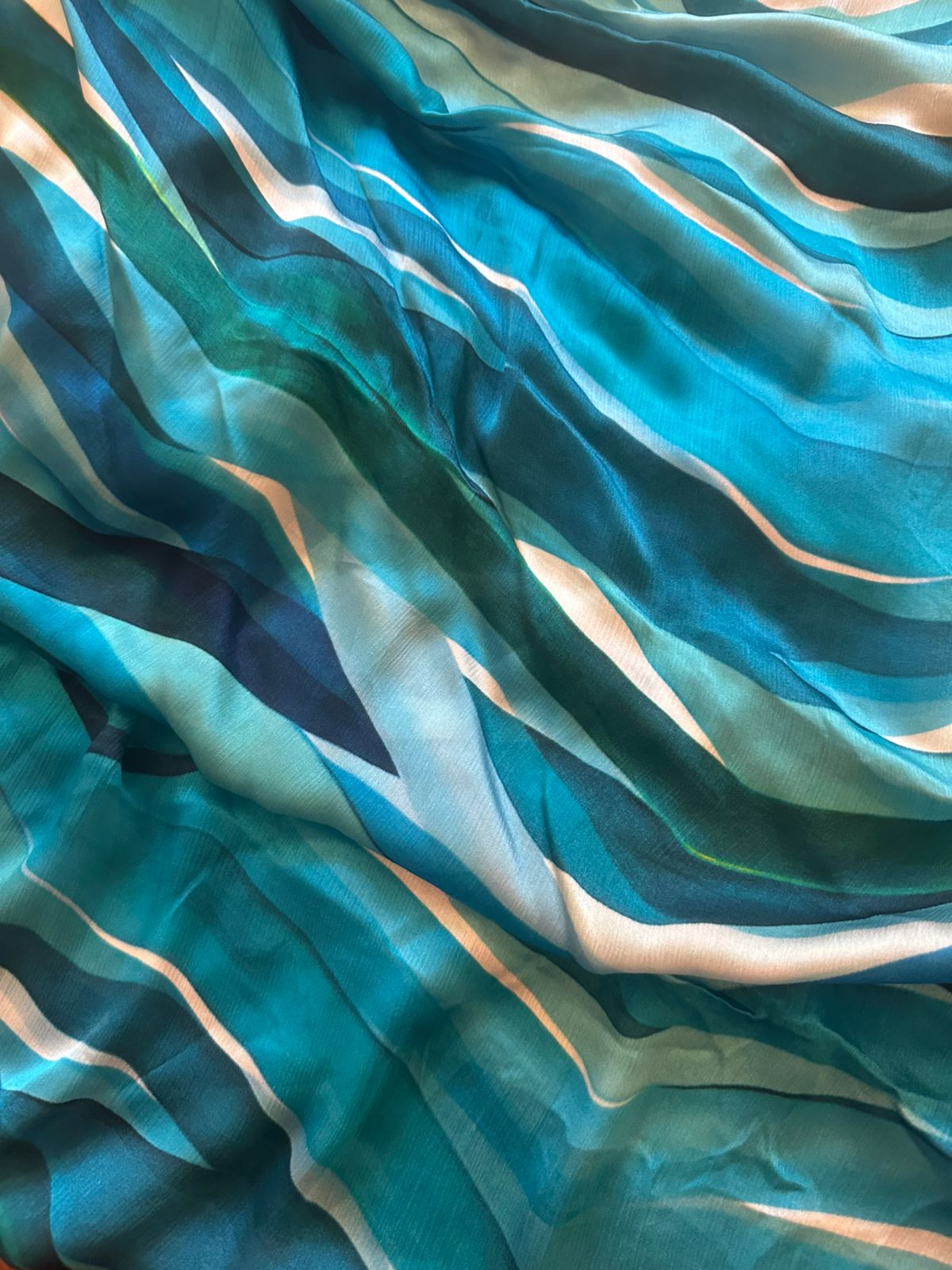 Close-up of a fabric with blue and green wavy pattern