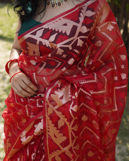 Person wearing a red and white patterned garment with a blurred natural background