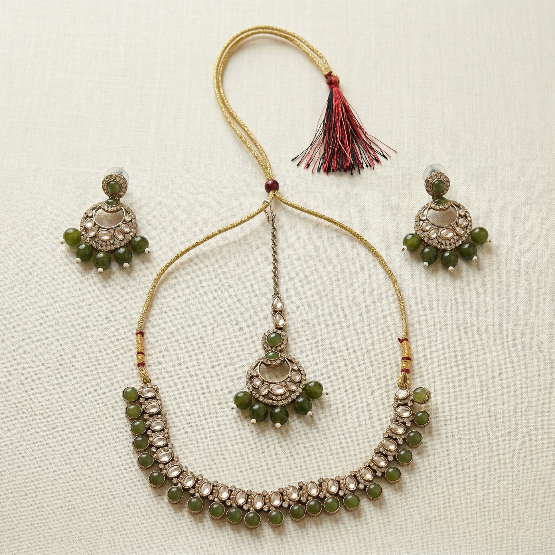 Jewelry set with necklace and earrings on a textured beige background