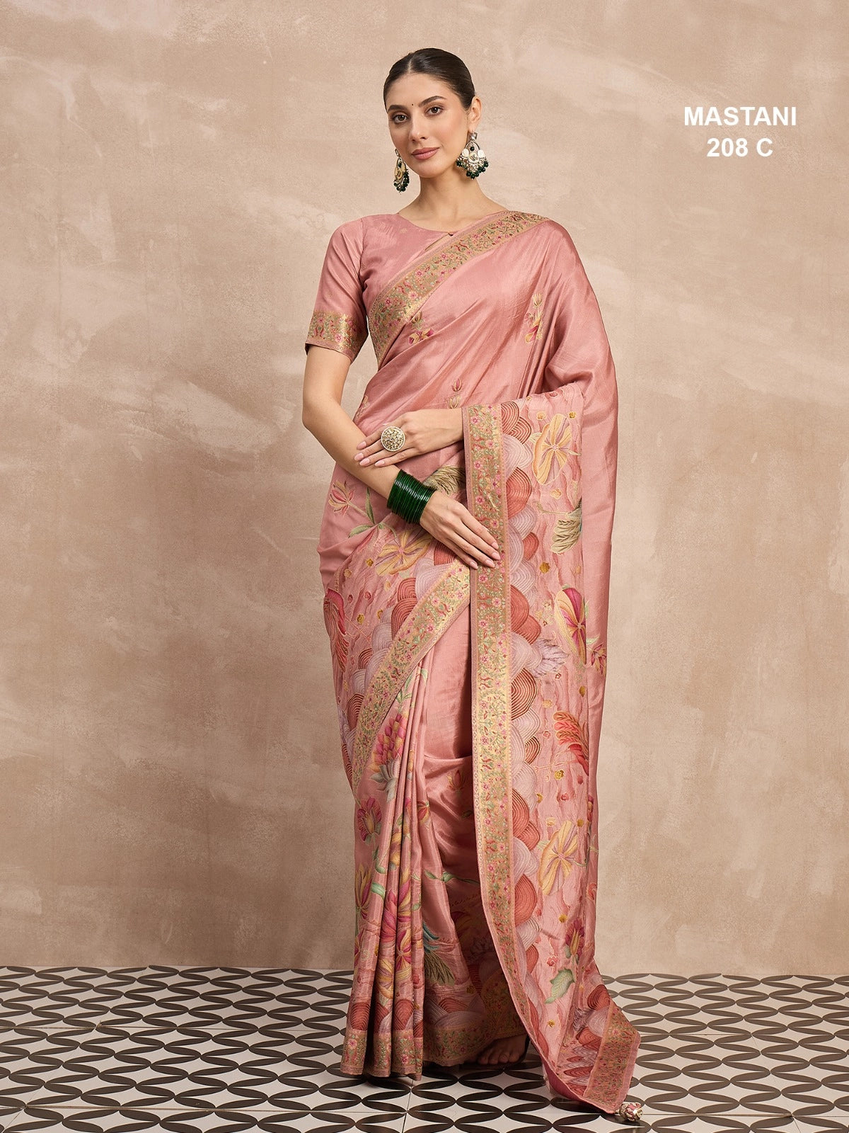 Woman wearing a pink saree with a floral pattern on a beige background