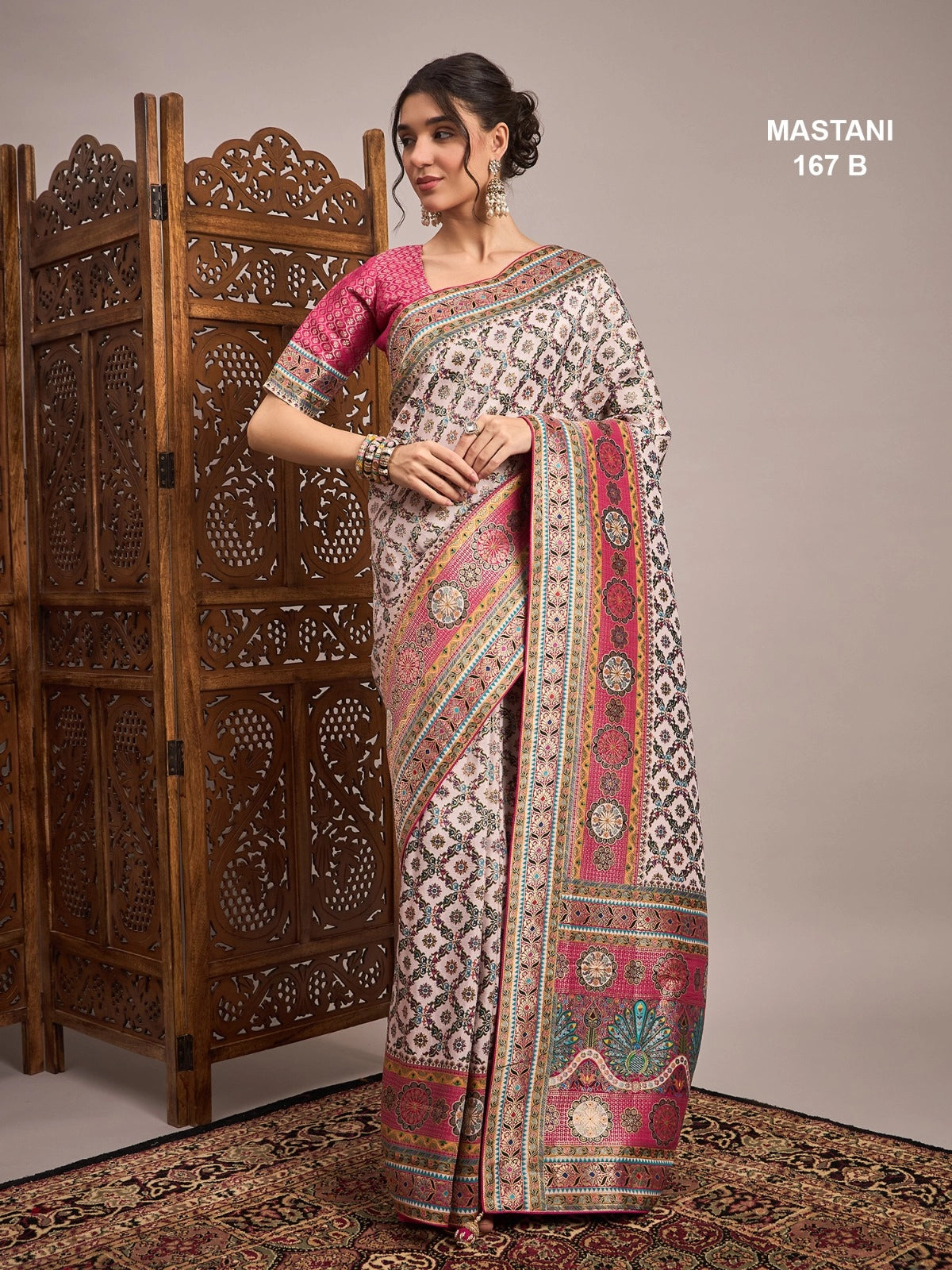 Woman wearing a traditional saree with intricate patterns in a decorative setting.