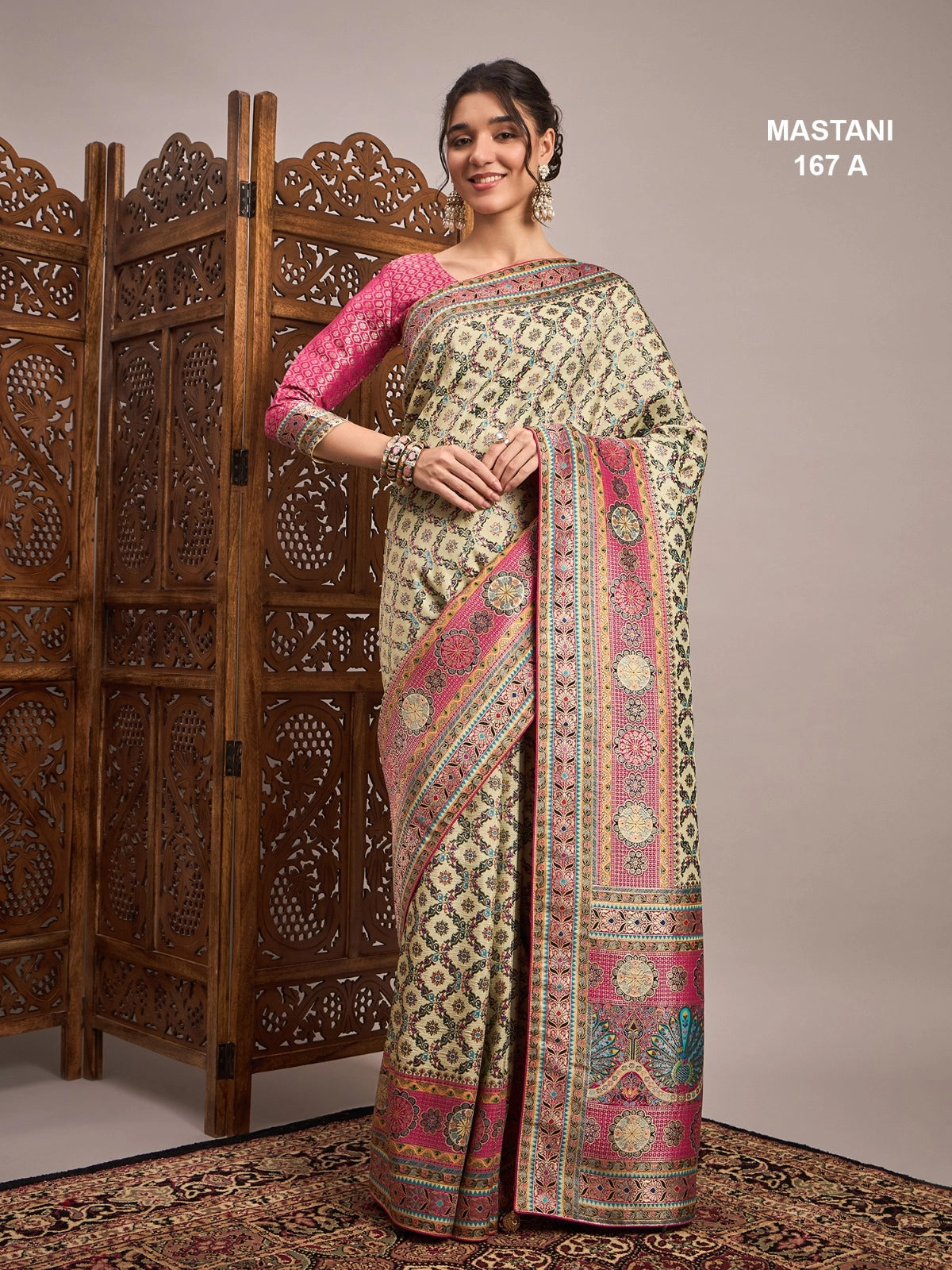 Woman wearing a patterned saree with a wooden screen in the background