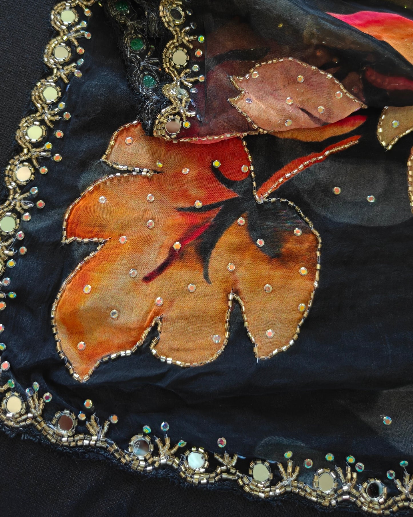 Close-up of embroidered fabric with floral patterns and embellishments.
