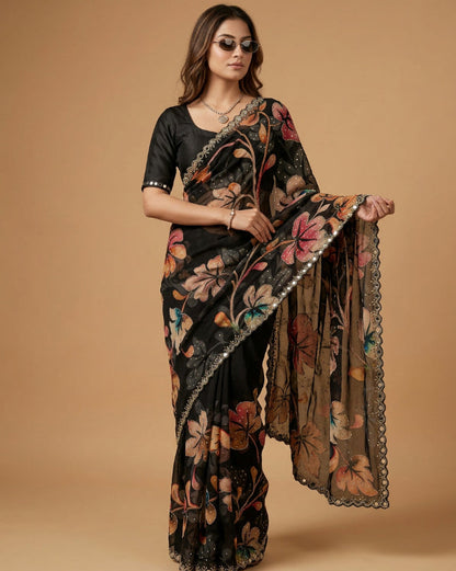 Woman wearing a black floral saree with a beige background