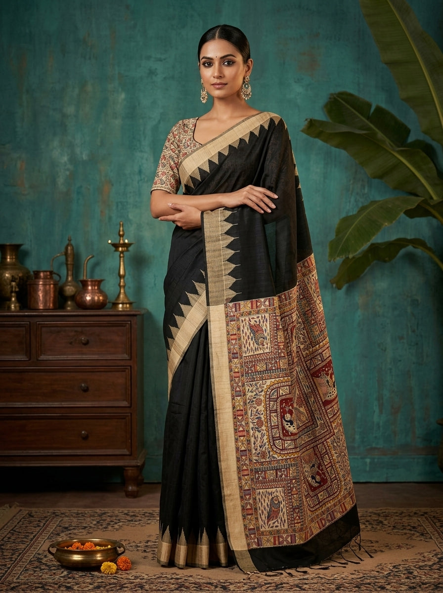 Woman wearing a black and patterned saree against a teal wall with decorative items.
